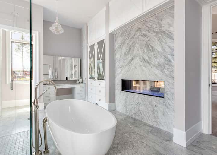 A stand alone tub sets off the beauty of bathroom marble tile in a remodeled Augusta, ME bathroom.